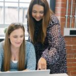 Two eventus consultants reading the report on a laptop