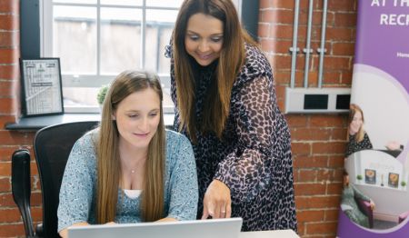 Two eventus consultants reading the report on a laptop